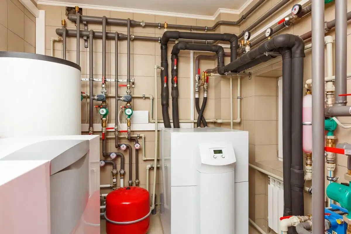Hybrid heat pump and gas boiler system installed in a residential boiler cupboard